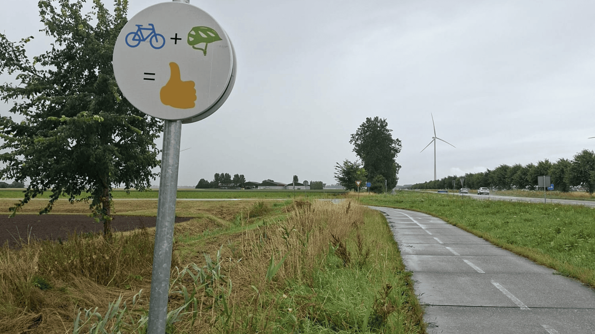 Complimentbord fietshelm: foto van bord met een fiets plus helm is duimpje omhoog.